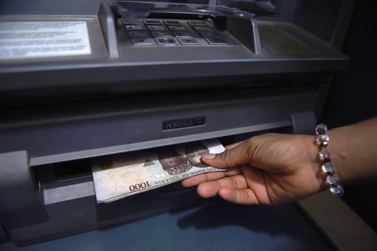 A customer withdraws Nigerian naira from an automated teller machine (ATM) at a bank in Asaba, Delta State, Nigeria, on November 10, 2016. (Photo by PIUS UTOMI EKPEI / AFP) (Photo by PIUS UTOMI EKPEI/AFP via Getty Images)