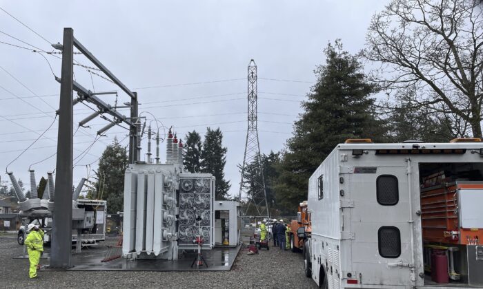 A Tacoma Power crew works at an electrical substation damaged by vandals early on Christmas morning after cutting a padlock to gain entry according to a crew manager in Graham, Wa. on Dec. 25, 2022. (Ken Lambert/The Seattle Times via AP)
