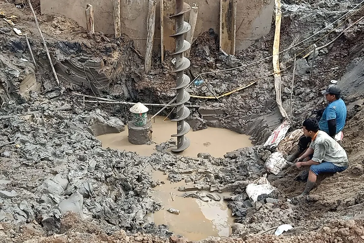 Rescuers gather at the site where a 10-year-old boy is thought to be trapped in a 35-meter deep shaft at a bridge construction area in Vietnam's Dong Thap Province on Jan. 2, 2023. (STR/AFP via Getty Images)