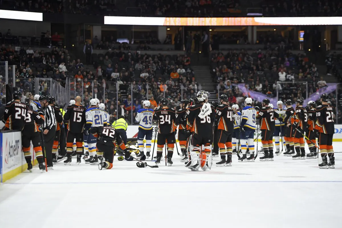 Members of the St. Louis Blues and Anaheim Ducks gather on the ice as Blues defenseman Jay Bouwmeester, who suffered a medical emergency, is worked on by medical personnel during the first period of an NHL hockey game in Anaheim, Calif., on Feb. 11, 2020. (Mark J. Terrill/AP Photo)