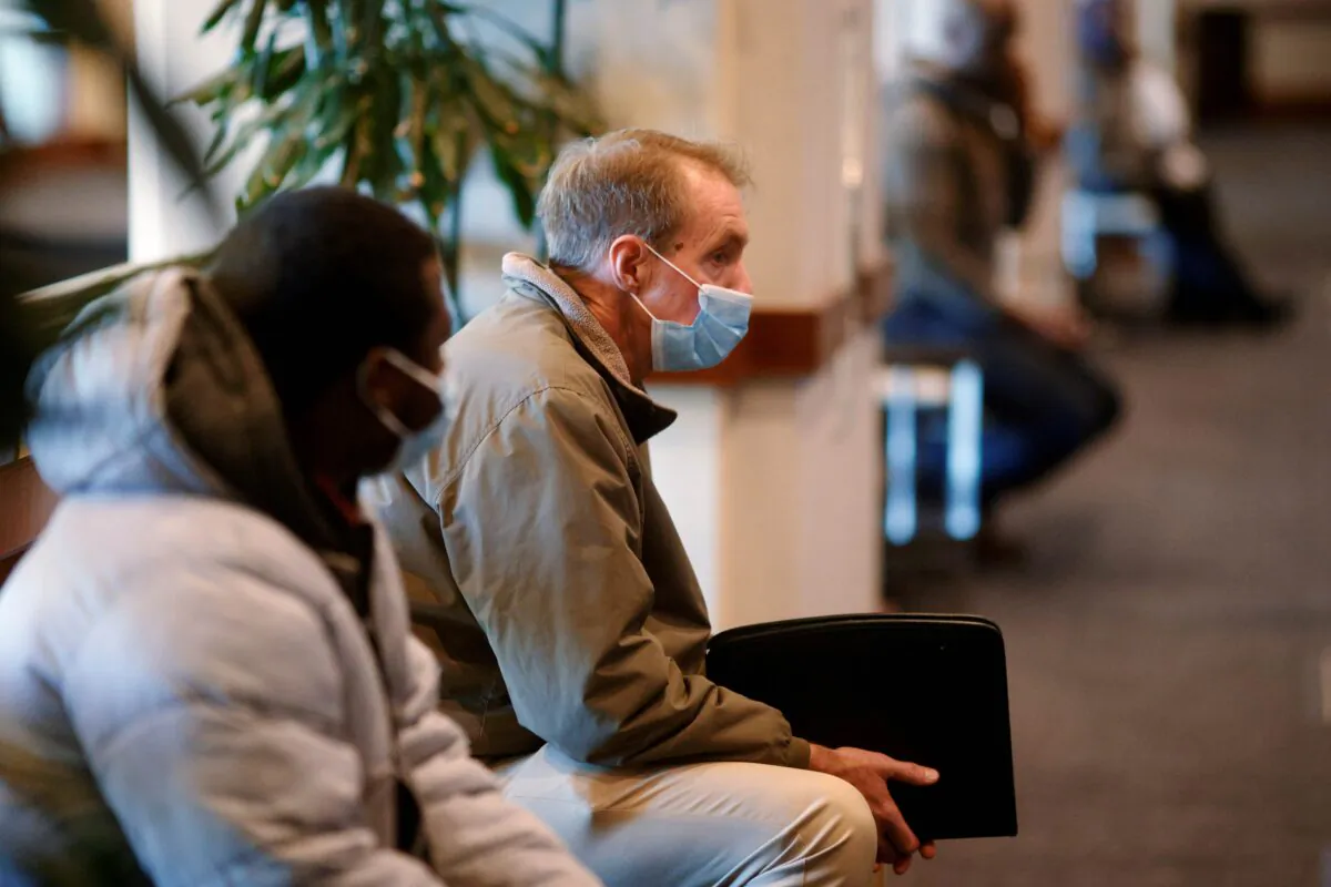 Job seekers wait before a job fair for airport related employment at Logan International Airport in Boston on Dec. 7, 2021. (Brian Snyder/Reuters)