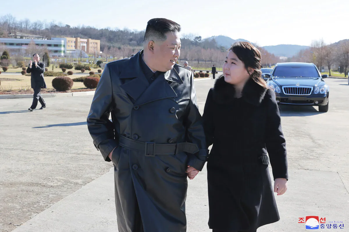 North Korean leader Kim Jong Un and his daughter (R) walk to a photo session with those involved in the recent launch of what it says a Hwasong-17 intercontinental ballistic missile, at an unidentified location in North Korea in an undated photo provided on Nov. 27, 2022. (Korean Central News Agency/Korea News Service via AP)