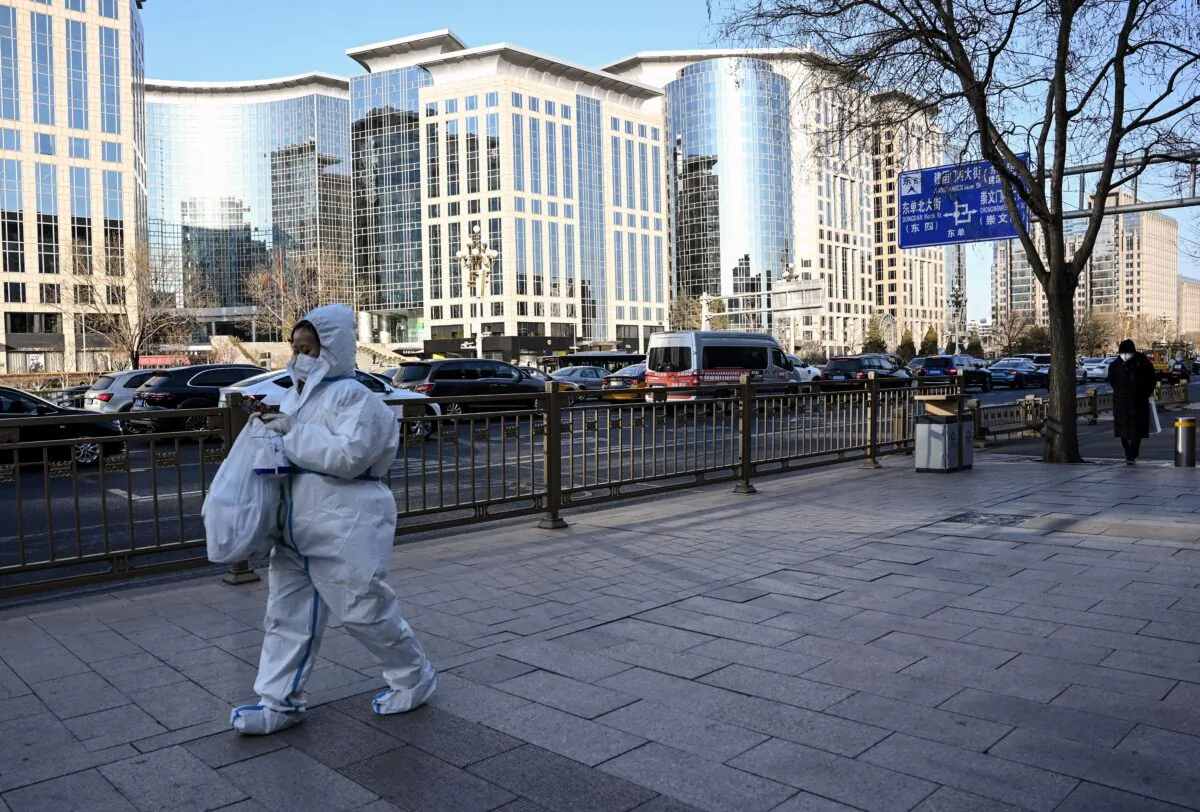 A woman wearing personal protective equipment (PPE) amid the COVID-19 pandemic walks along a street in Beijing on Dec. 26, 2022. (Noel Celis/AFP via Getty Images)