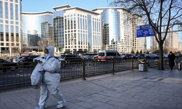 A woman wearing personal protective equipment (PPE) amid the COVID-19 pandemic walks along a street in Beijing on Dec. 26, 2022. (Noel Celis/AFP via Getty Images)