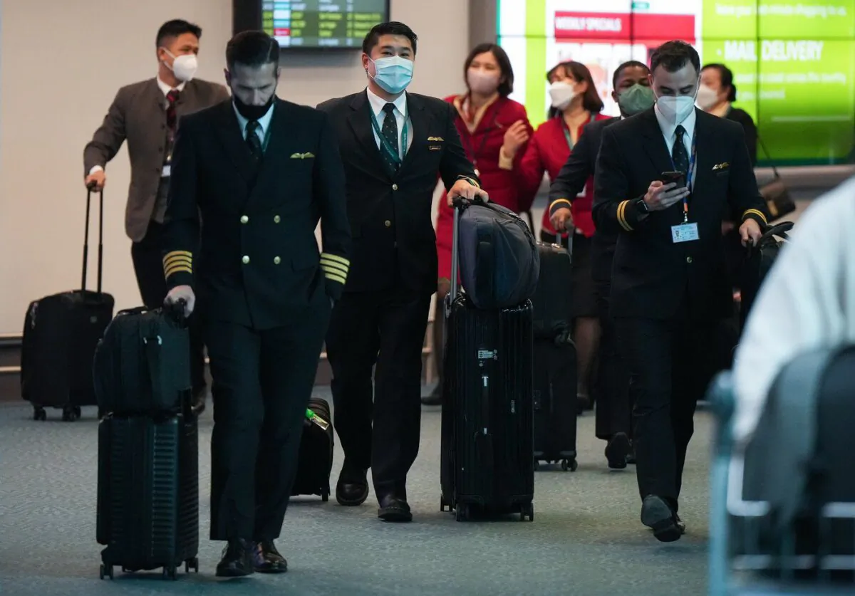 Cathay Pacific crew members who worked on a flight from Hong Kong arrive at Vancouver International Airport, in Richmond, B.C., on Jan. 4, 2023. (The Canadian Press/Darryl Dyck)