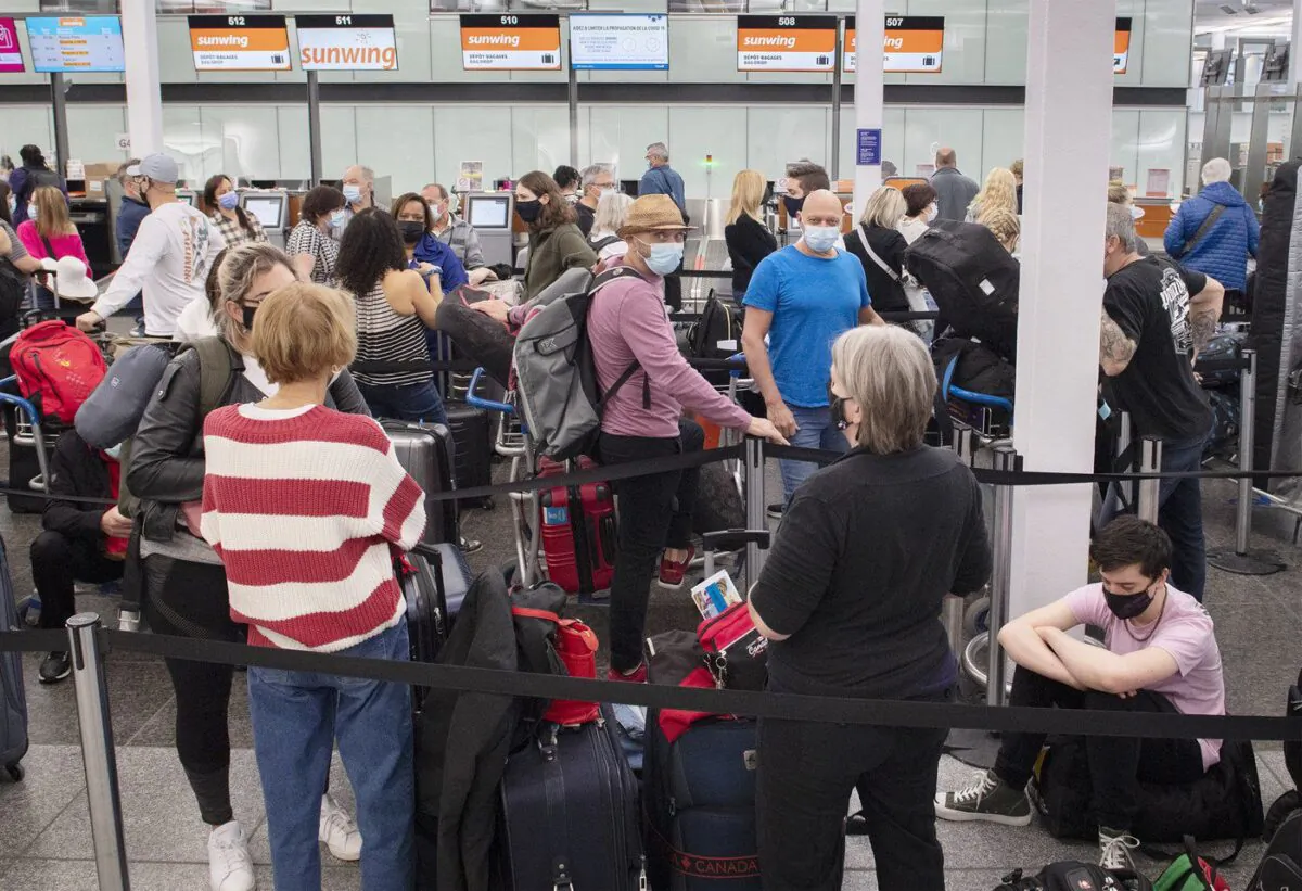 Travellers wait in line at a Sunwing Airlines check-in desk at Trudeau Airport in Montreal, April 20, 2022. (The Canadian Press/Graham Hughes)
