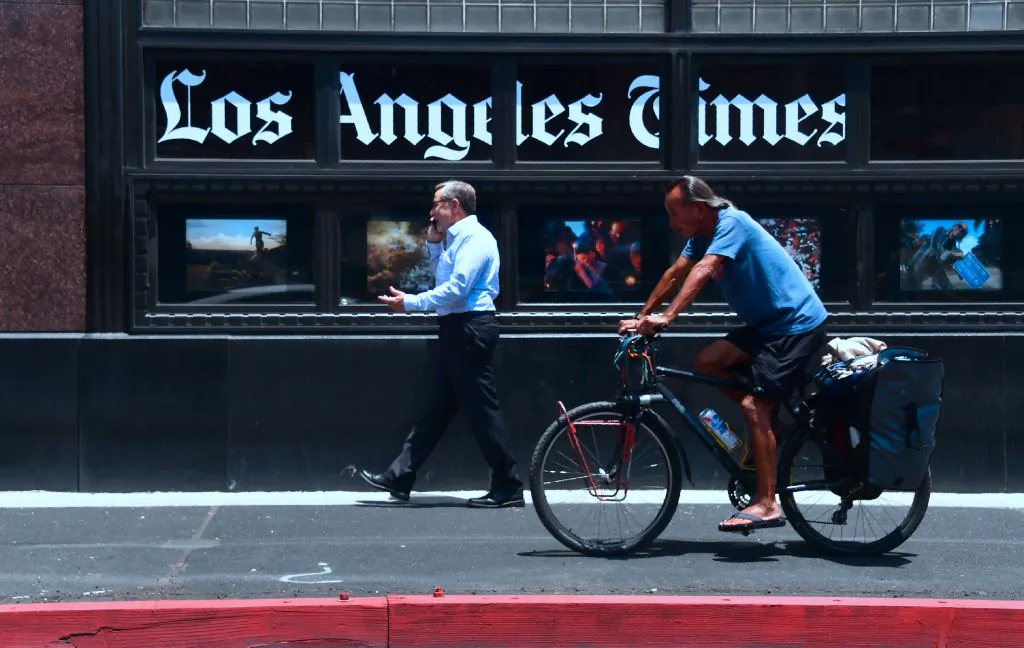 People make their way past the Los Angeles Times office building in downtown Los Angeles on July 16, 2018. (Frederic J. Brown/AFP via Getty Images)