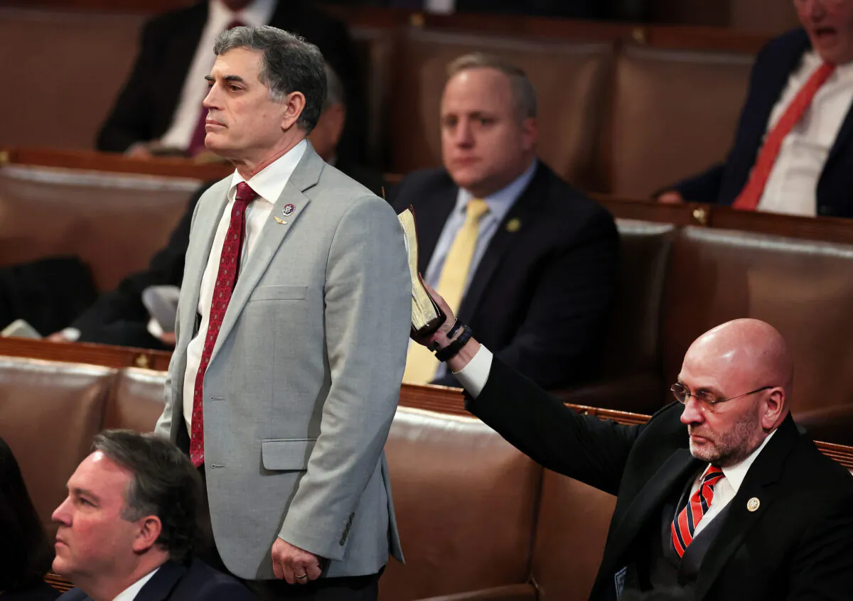 U.S. Rep.-elect Clay Higgins (R-LA) (R) puts a bible on the back of Rep.-elect Andrew Clyde (R-GA) as he votes for House Republican Leader Kevin McCarthy (R-CA) in the House Chamber during the fourth day of elections for Speaker of the House at the U.S. Capitol Building in Washington on Jan. 6, 2023. (Win McNamee/Getty Images)