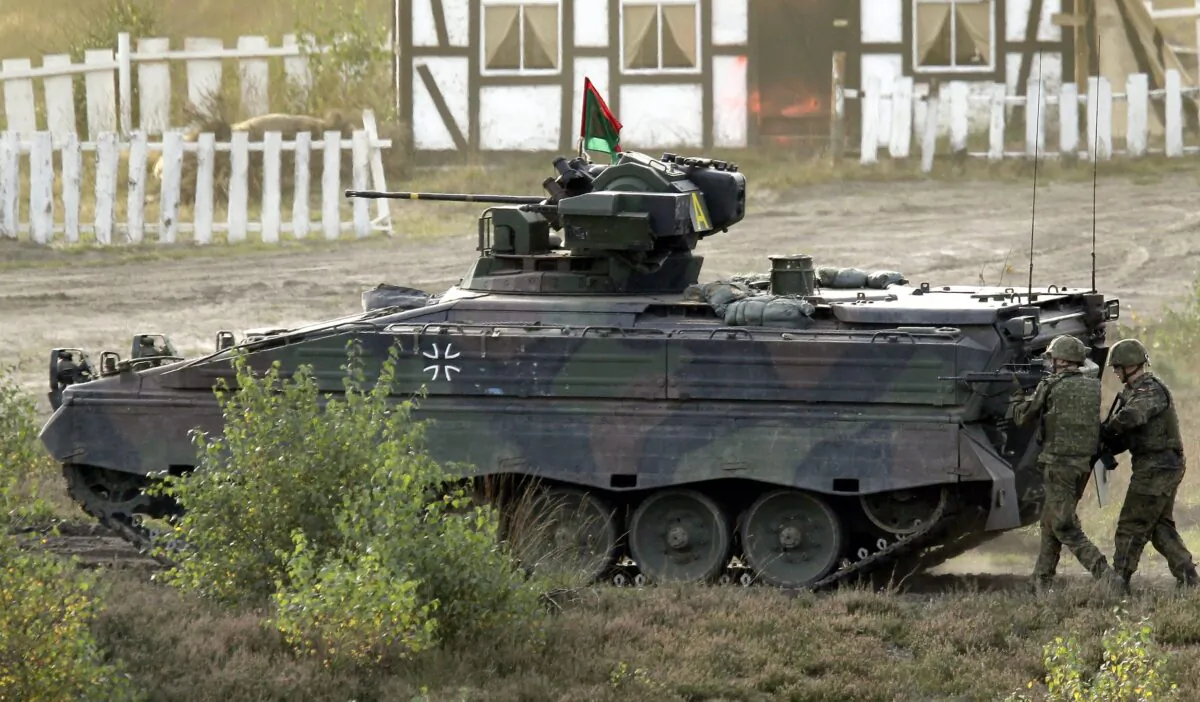 Soldiers follow a Marder infantry fighting vehicle during a demonstration event held for the media by the German Bundeswehr in Bergen near Hannover, Germany, on Sept. 28, 2011. (Michael Sohn/AP Photo)
