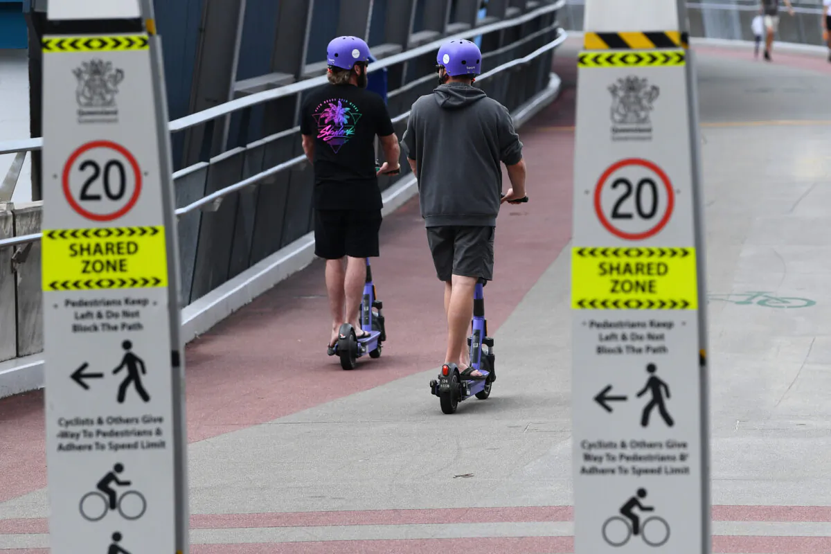 E-scooters are seen being ridden in Brisbane. (AAP Image/Jono Searle)