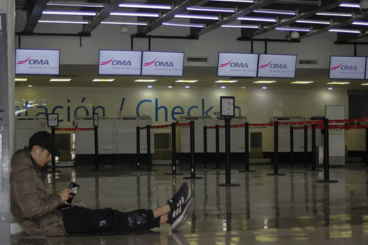 A passenger waits in an empty terminal at the airport while flights are suspended due to drug cartel-related violence in Culiacan, Sinaloa state, Mexico on Jan. 6, 2023. (The Canadian Press/AP, Martin Urista)

