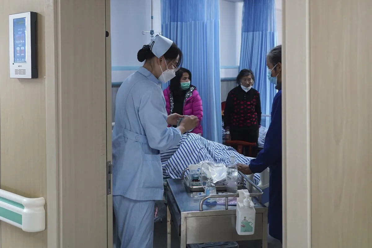 Medical workers check on an elderly patient in a hospital in Beijing on Jan. 7, 2023. (Andy Wong/AP Photo)