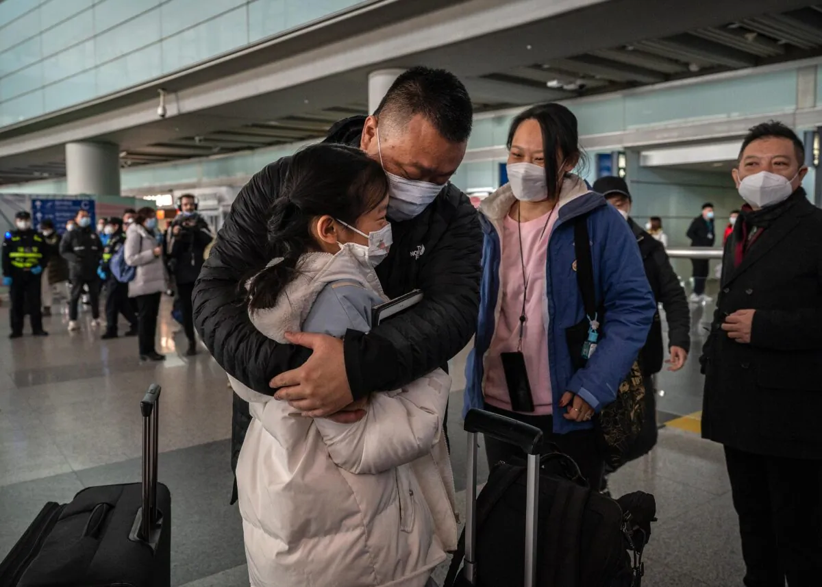 A man hugs his daughter in the international arrivals area of Beijing Capital Airport in Beijing on Jan. 8, 2023. (Kevin Frayer/Getty Images)