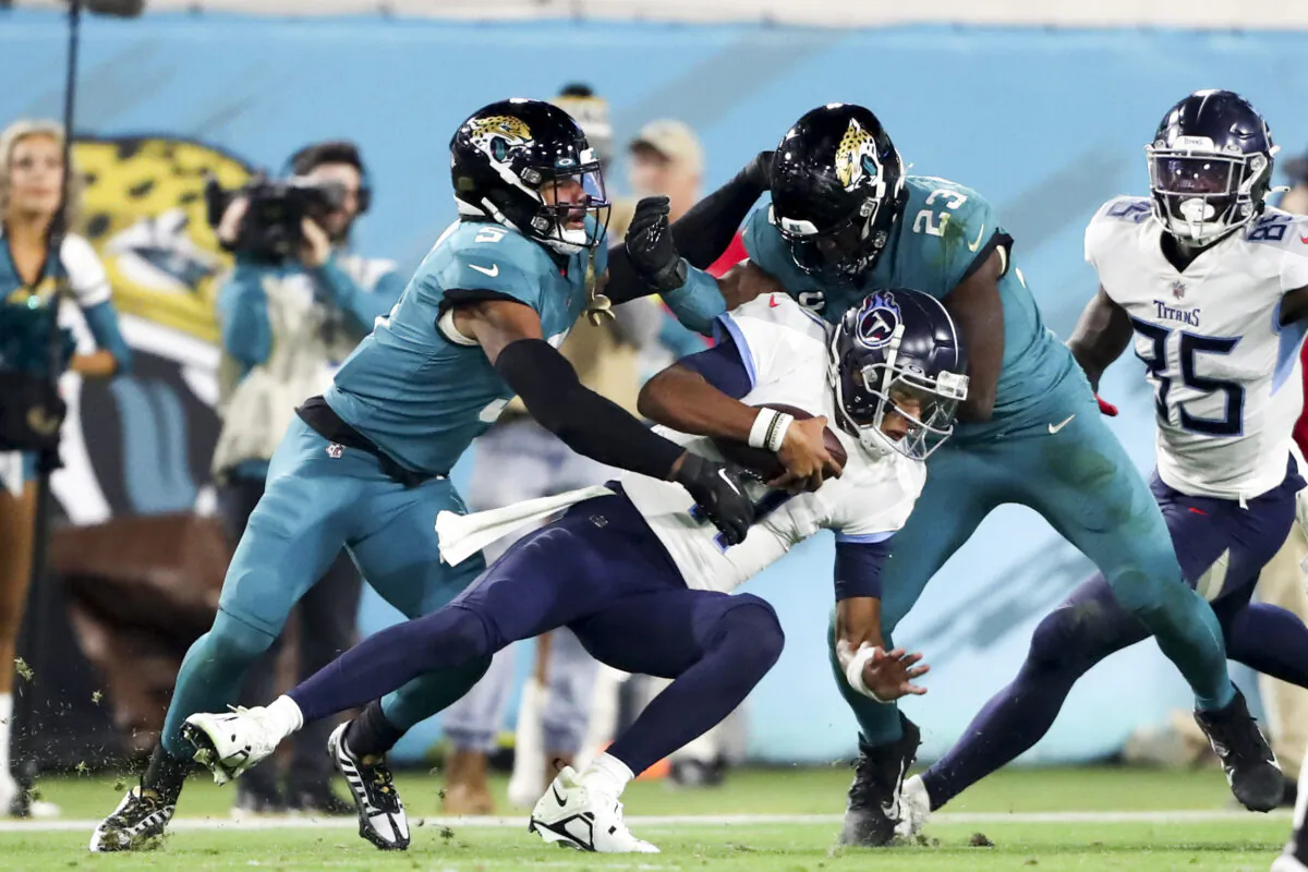 Andre Cisco (5) of the Jacksonville Jaguars and Foyesade Oluokun (23) of the Jacksonville Jaguars sack Joshua Dobbs (11) of the Tennessee Titans during the second quarter at TIAA Bank Field in Jacksonville, Fla. on Jan. 7, 2023. (Courtney Culbreath/Getty Images)