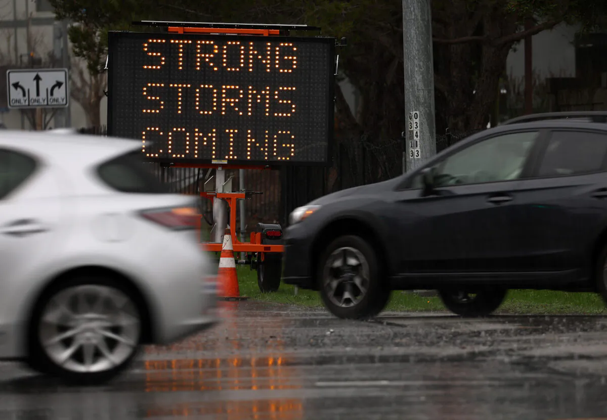 Cars drive by a sign warning of storms hitting the Bay Area in Sausalito, California, on Jan. 7, 2023. (Justin Sullivan/Getty Images)