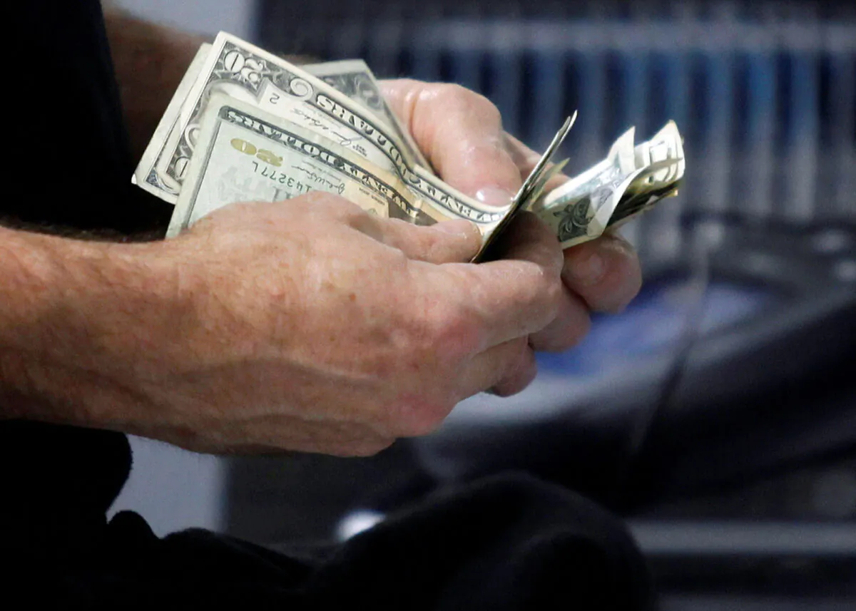 A customer counts his cash at the register while purchasing an item at a Best Buy store in Flushing, New York, on March 27, 2010. (Jessica Rinaldi/Reuters)