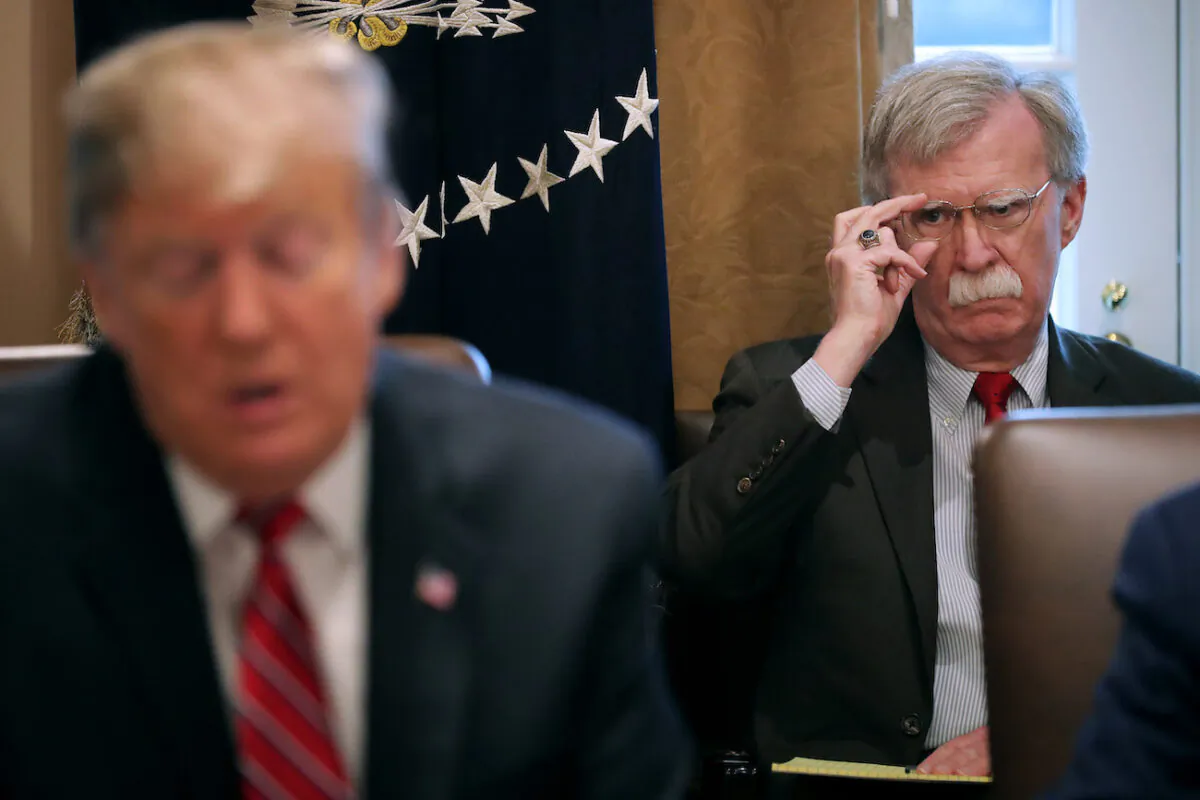 Then-national security adviser John Bolton (R) listens to then-President Donald Trump talk to reporters during a meeting of his cabinet in the Cabinet Room at the White House in Washington, on Feb. 12, 2019. (Chip Somodevilla/Getty Images)