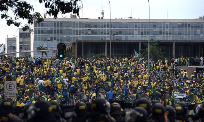 Protestujący, z których wielu popiera byłego prezydenta Brazylii Jaira Bolsonaro, otaczają kilka budynków rządowych, gdy stają przed siłami bezpieczeństwa w Brasilii 8 stycznia 2023 r. (Ton Molina/AFP via Getty Images)