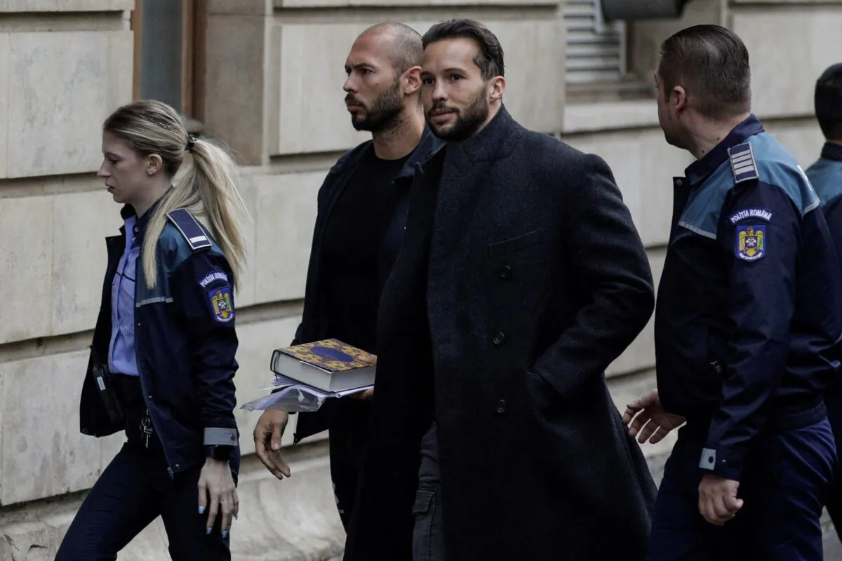 Andrew Tate and his brother Tristan are escorted by police officers outside the headquarters of the Bucharest Court of Appeal in Bucharest, Romania, on Jan. 10, 2023. (Inquam Photos/Octav Ganea via Reuters)