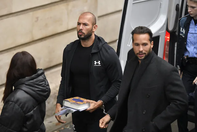 Andrew Tate (C) and his brother Tristan (R) are brought by police officers to the Court of Appeal, in Bucharest, Romania, on Jan.10, 2023. (Alexandru Dobre/AP Photo)