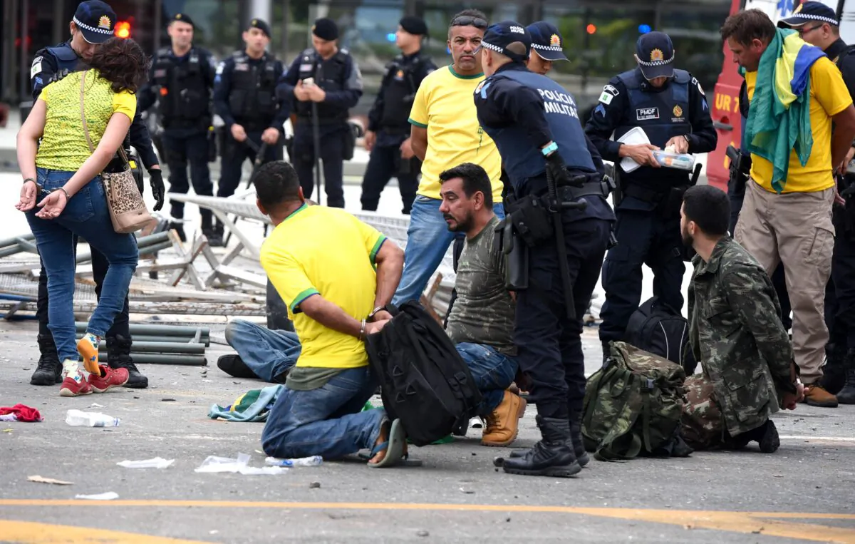 Security forces arrest supporters of Brazilian former President Jair Bolsonaro after retaking control of Planalto Presidential Palace in Brasilia on January 8, 2023. (TON MOLINA/AFP via Getty Images)