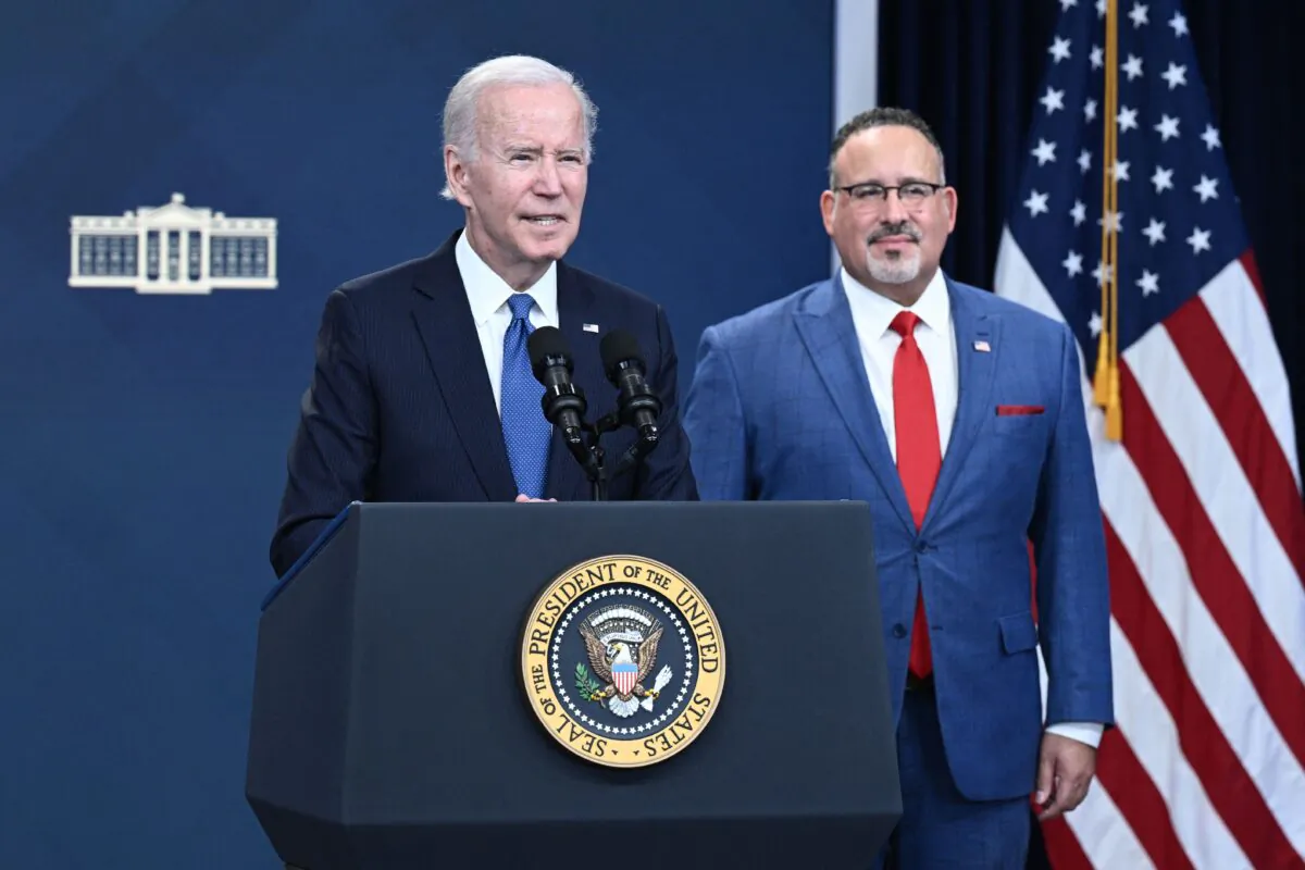 US Education Secretary Miguel Cardona (R) looks on as US President Joe Biden delivers remarks on the student debt relief portal beta test, in the South Court Auditorium of the Eisenhower Executive Office Building, next to the White House, in Washington on Oct. 17, 2022. (Brendan Smialowski/AFP via Getty Images)