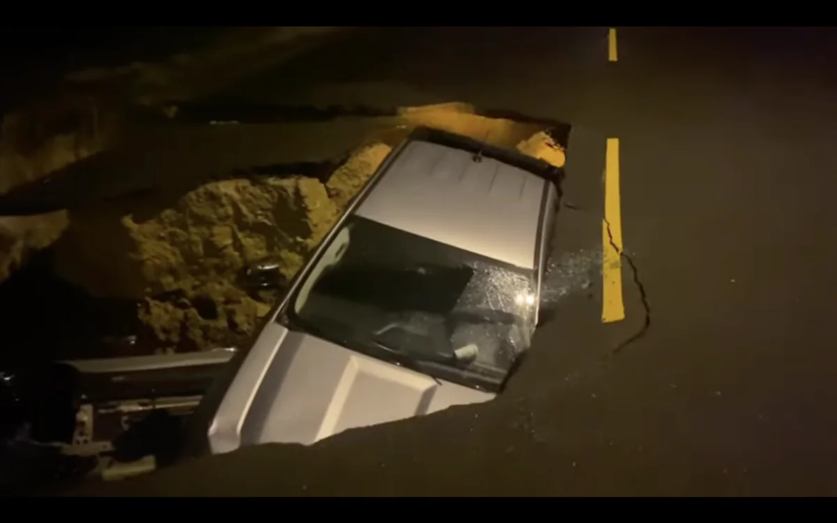 Two vehicles fall on top of each other in a large sinkhole in Chatsworth, Calif., on Jan. 9, 2023.(Screenshot via YouTube/LAFD) 

