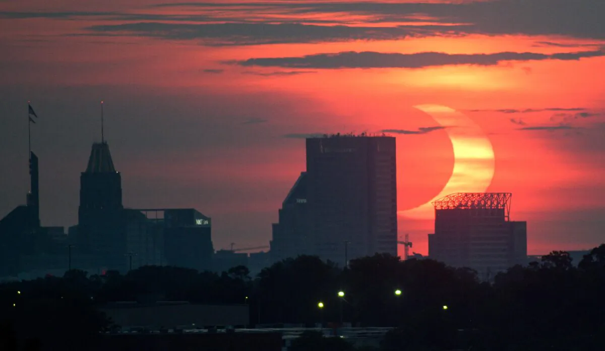 The sun and moon rise together over downtown Baltimore in partial eclipse in June 2021. (Jerry Jackson/Baltimore Sun/TNS)