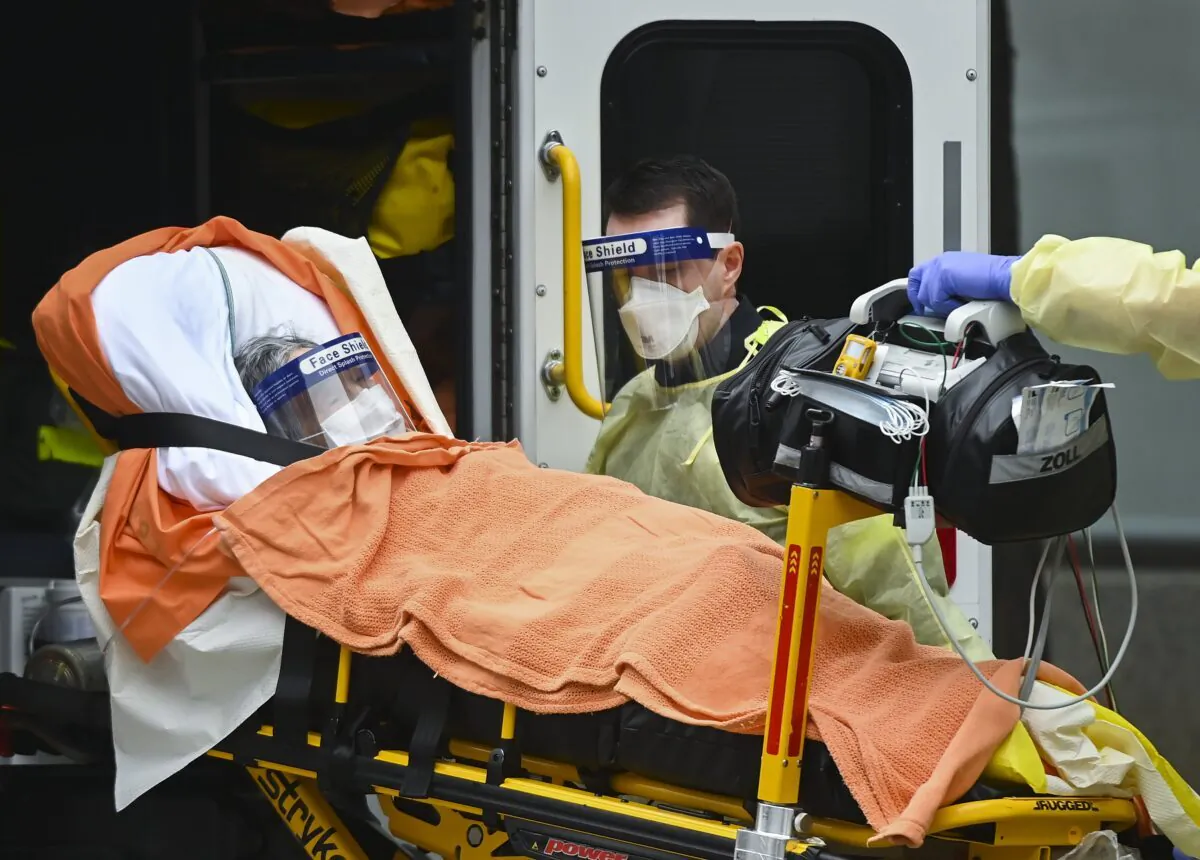 Paramedics take away an elderly patient at a long-term-care facility during the COVID-19 pandemic in Scarborough, Ont., Canada, on Dec. 23, 2020. (Nathan Denette/The Canadian Press)