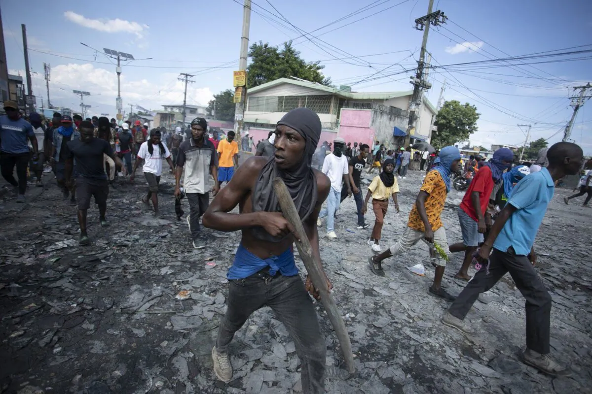 A protester carries a piece of wood simulating a weapon during a protest demanding the resignation of Prime Minister Ariel Henry in the Petion-Ville area of Port-au-Prince, Haiti, on Oct. 3, 2022. (The Canadian Press/AP-Odelyn Joseph)
