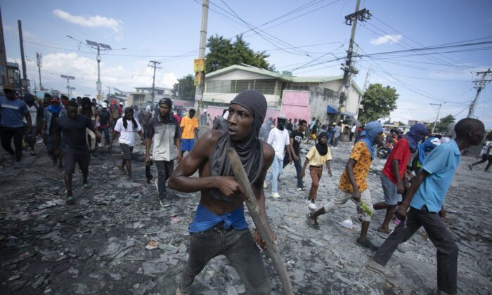 A protester carries a piece of wood simulating a weapon during a protest demanding the resignation of Prime Minister Ariel Henry in the Petion-Ville area of Port-au-Prince, Haiti, on Oct. 3, 2022. (The Canadian Press/AP-Odelyn Joseph)
