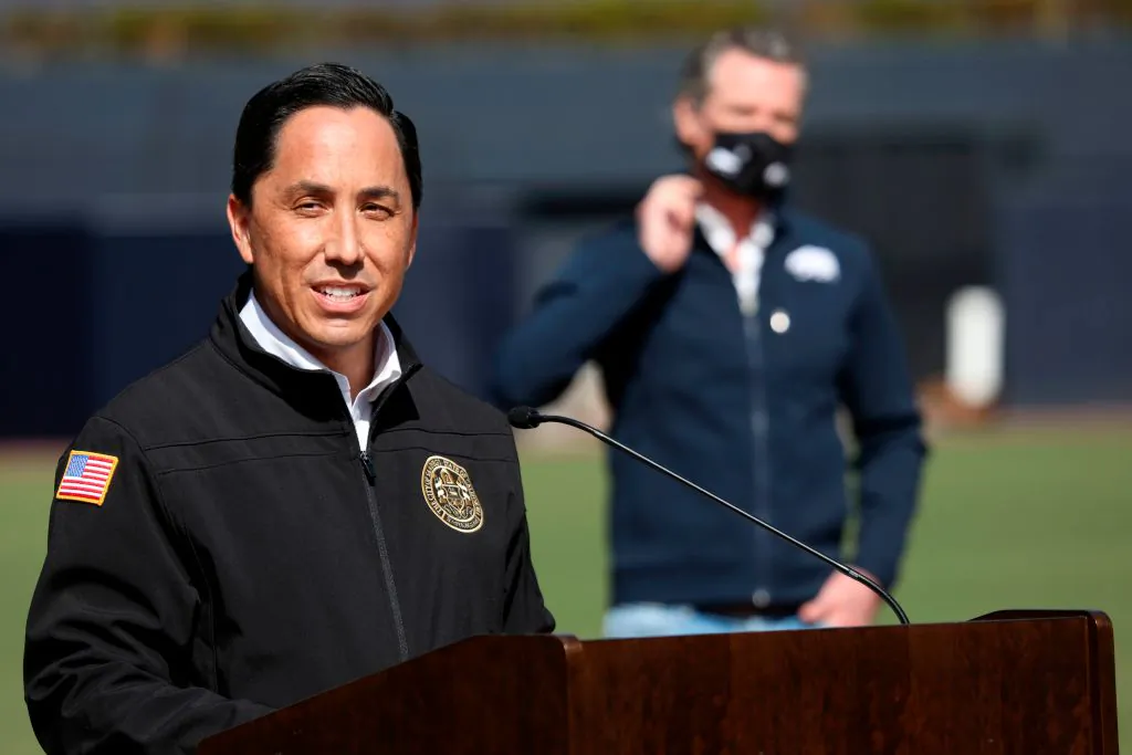 California Gov. Gavin Newsom (R) listens as San Diego Mayor Todd Gloria speaks to members of the media during a press conference at Petco Park in San Diego on Feb. 8, 2021. (Sandy Huffaker/AFP via Getty Images)