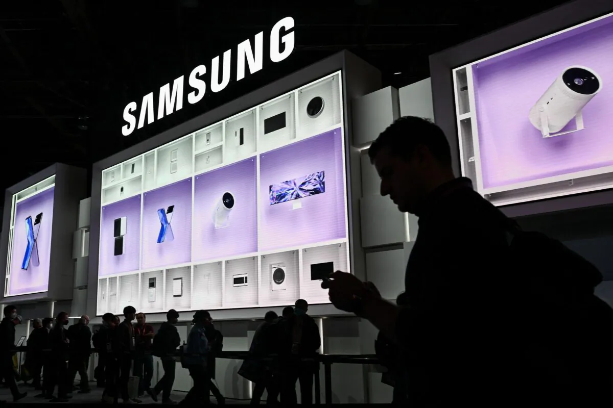 Attendees wait in line beneath a large LED display of smart connected home products to enter the Samsung Electronics booth during the Consumer Electronics Show in Las Vegas on Jan. 6, 2023. (Patrick T. Fallon/AFP via Getty Images)