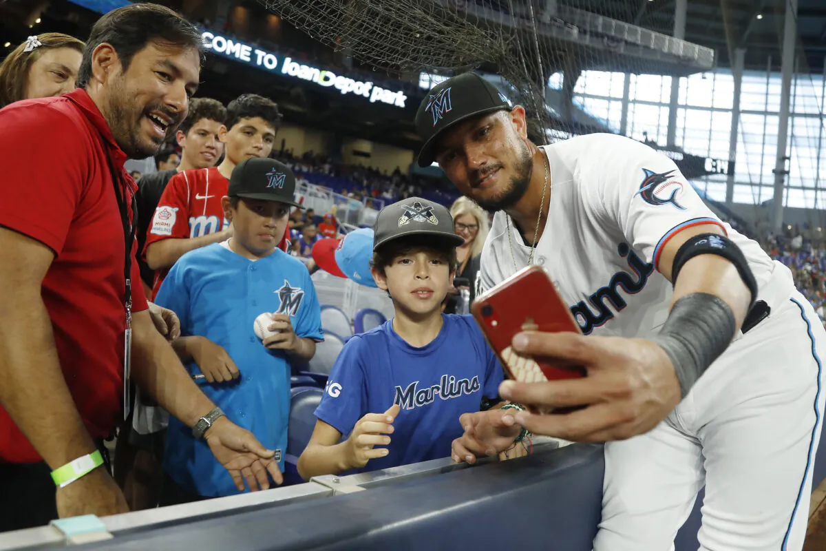 Miguel Rojas (11) of the Miami Marlins signs a autograph for fans prior to the game against the Philadelphia Phillies at loanDepot park in Miami on April 14, 2022. (Michael Reaves/Getty Images)