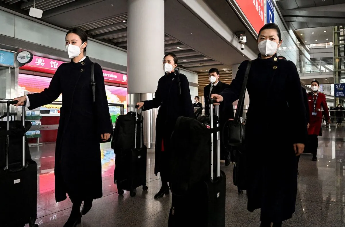 Flight attendants walk at the arrival area at the Beijing Capital International Airport in Beijing on Jan. 8, 2023. (Noel Celis/AFP via Getty Images)