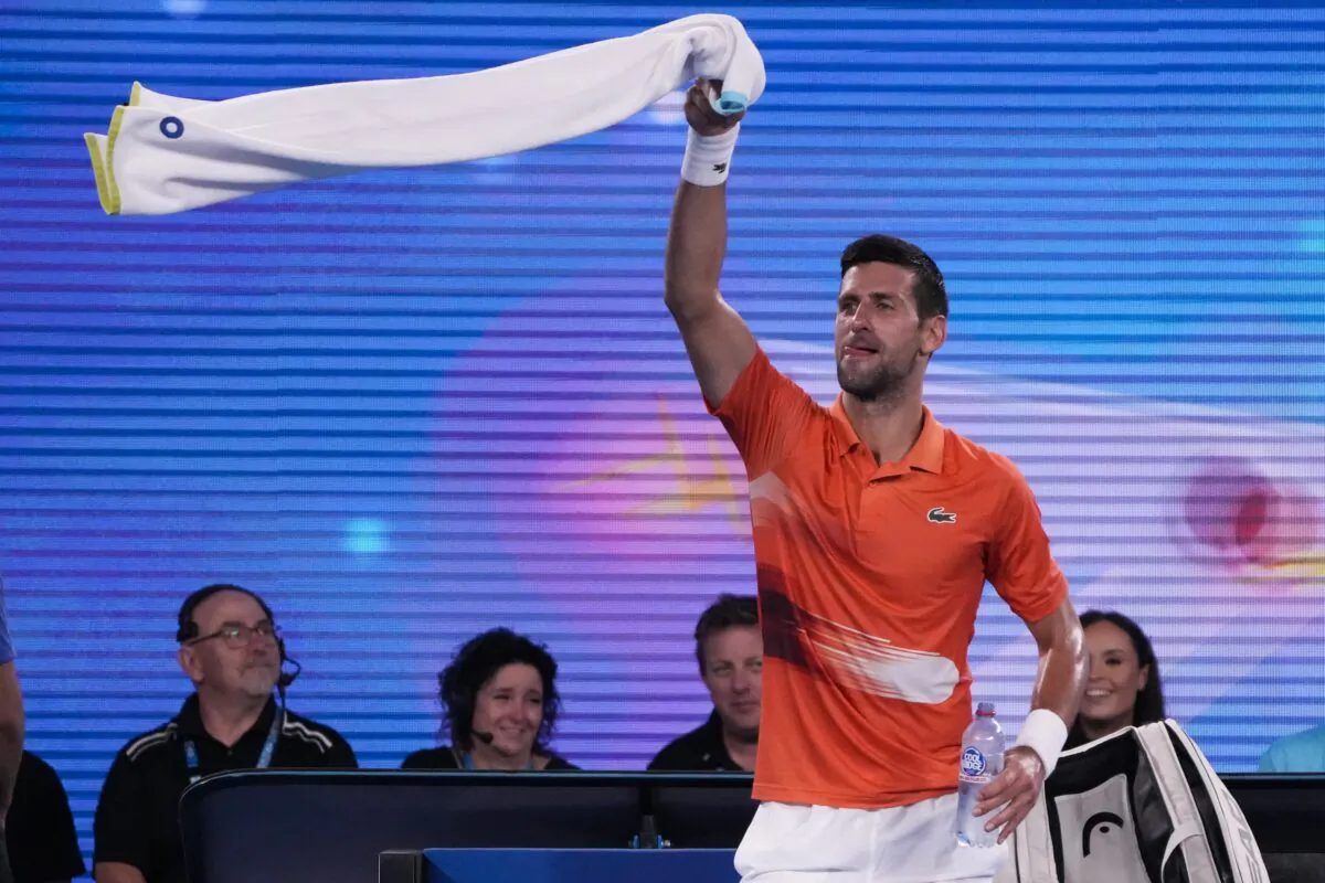 Serbia's Novak Djokovic swings his towel as he dances between games during an exhibition match against Australia's Nick Kyrgios on Rod Laver Arena ahead of the Australian Open tennis championship in Melbourne, Australia, on Jan. 13, 2023. (Mark Baker/AP Photo)