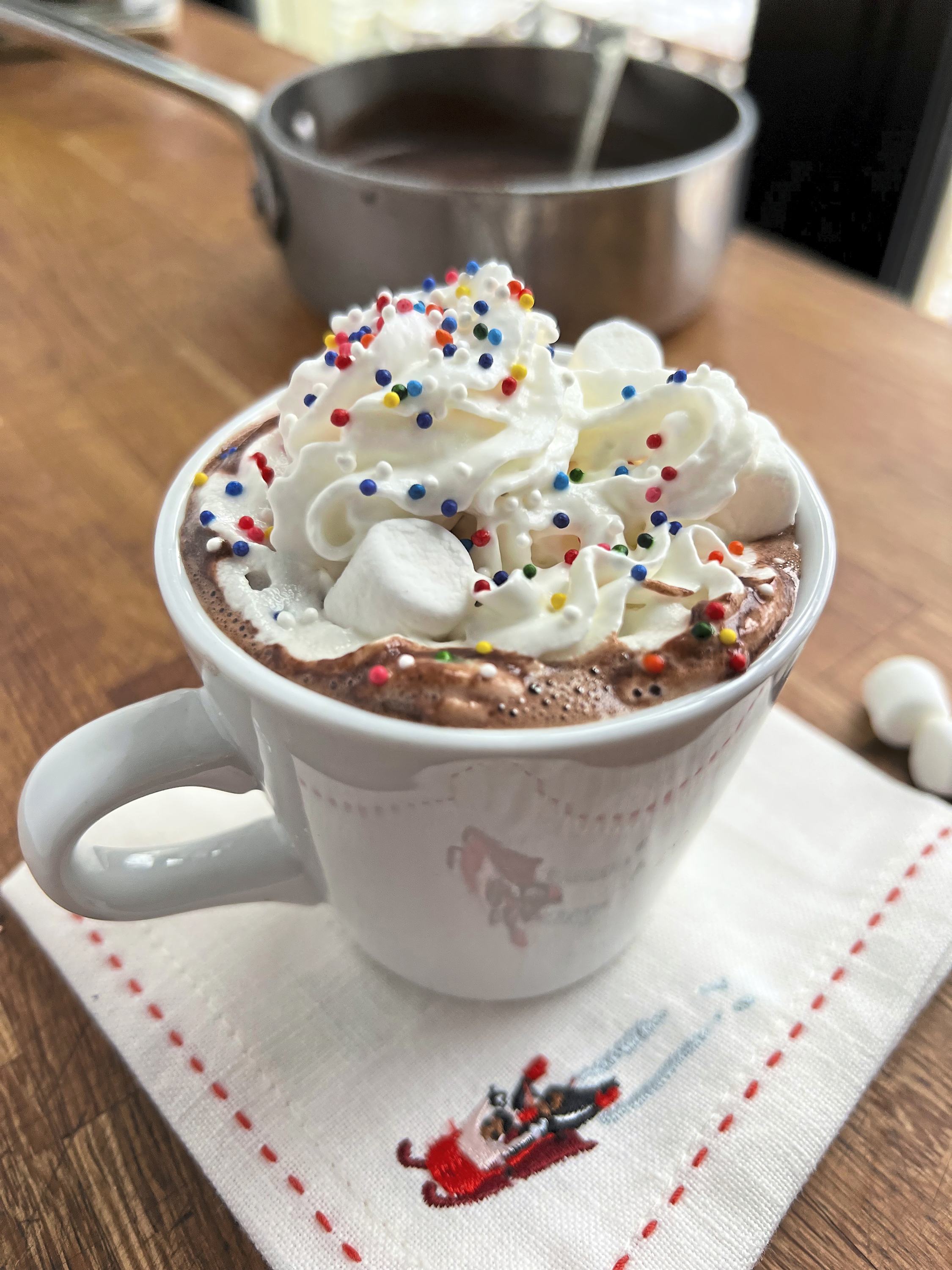 Hot cocoa topped with whipped cream and sprinkles