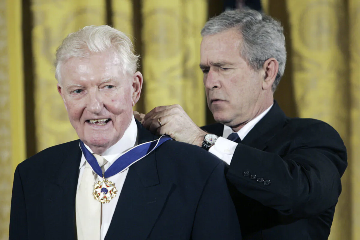 Historian and journalist Paul Johnson, (L), receives the Presidential Medal of Freedom from United States President Bush during a ceremony in the East Room of the White House on Dec. 15, 2006. (Pablo Martinez Monsivais/AP Photo)
