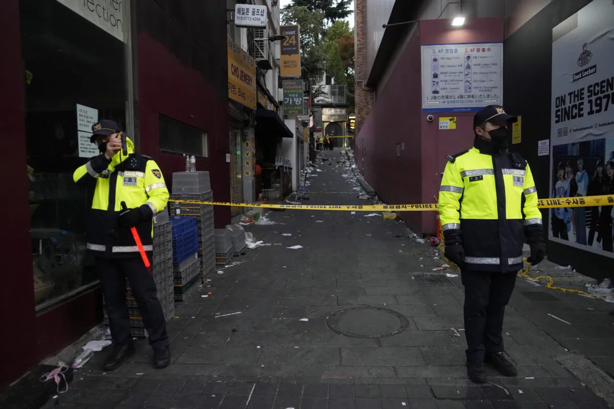 Police officers stand guard at the scene where dozens of people died and were injured during a crowd surge in Seoul, South Korea, on Oct. 30, 2022. (Ahn Young-joon/AP Photo)
