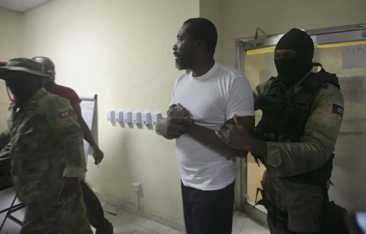 Former lawmaker Arnel Belizaire is escorted by national police to be presented to the press in Port-au-Prince, Haiti, Dec. 4, 2019. (The Canadian Press/AP-Dieu Nalio Chery)
