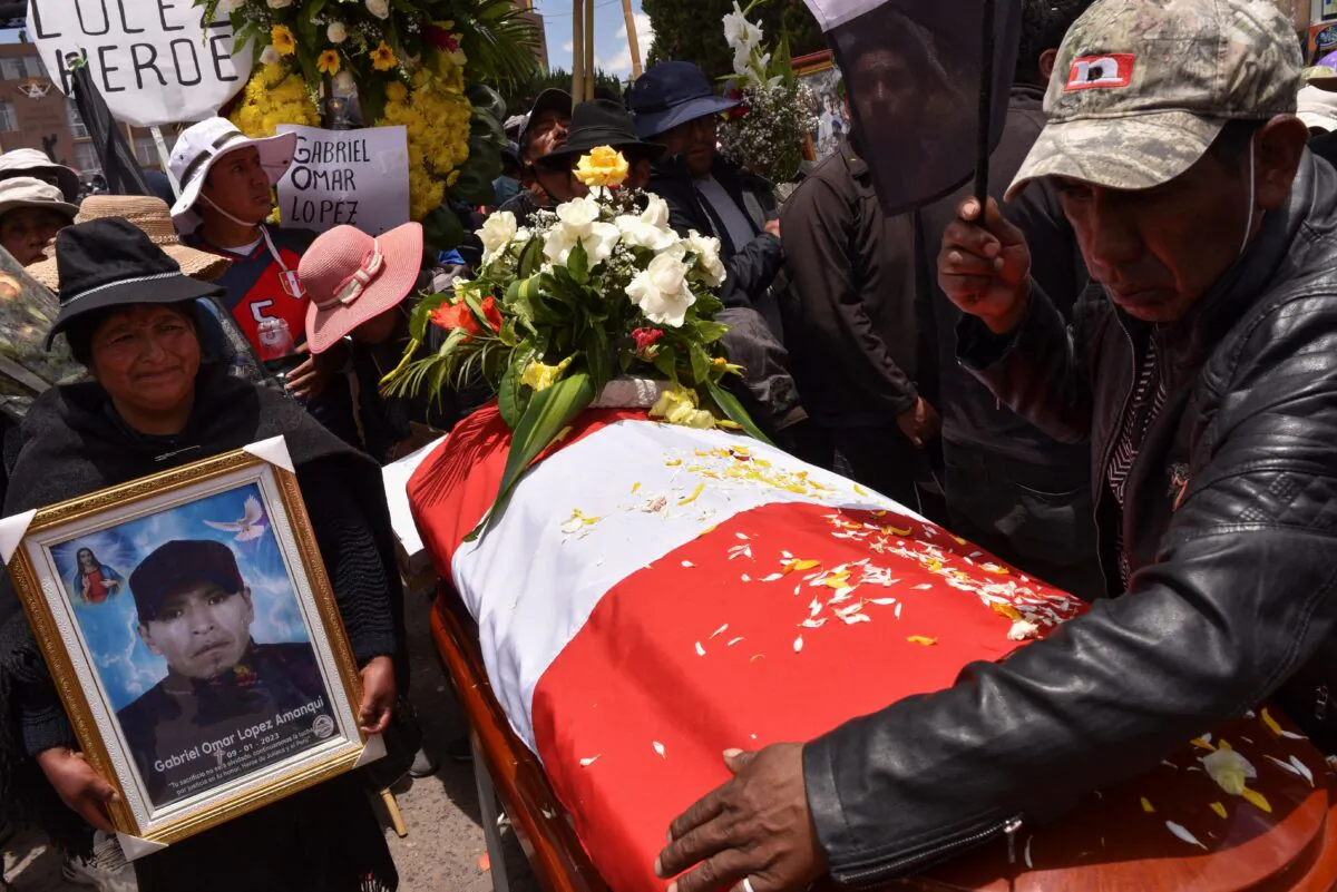People react near the coffin of a man who died in violent clashes earlier this week, ignited by the ouster of leftist President Pedro Castillo, in Juliaca, Peru, on Jan. 11, 2023. (Pedro Anza/Reuters)