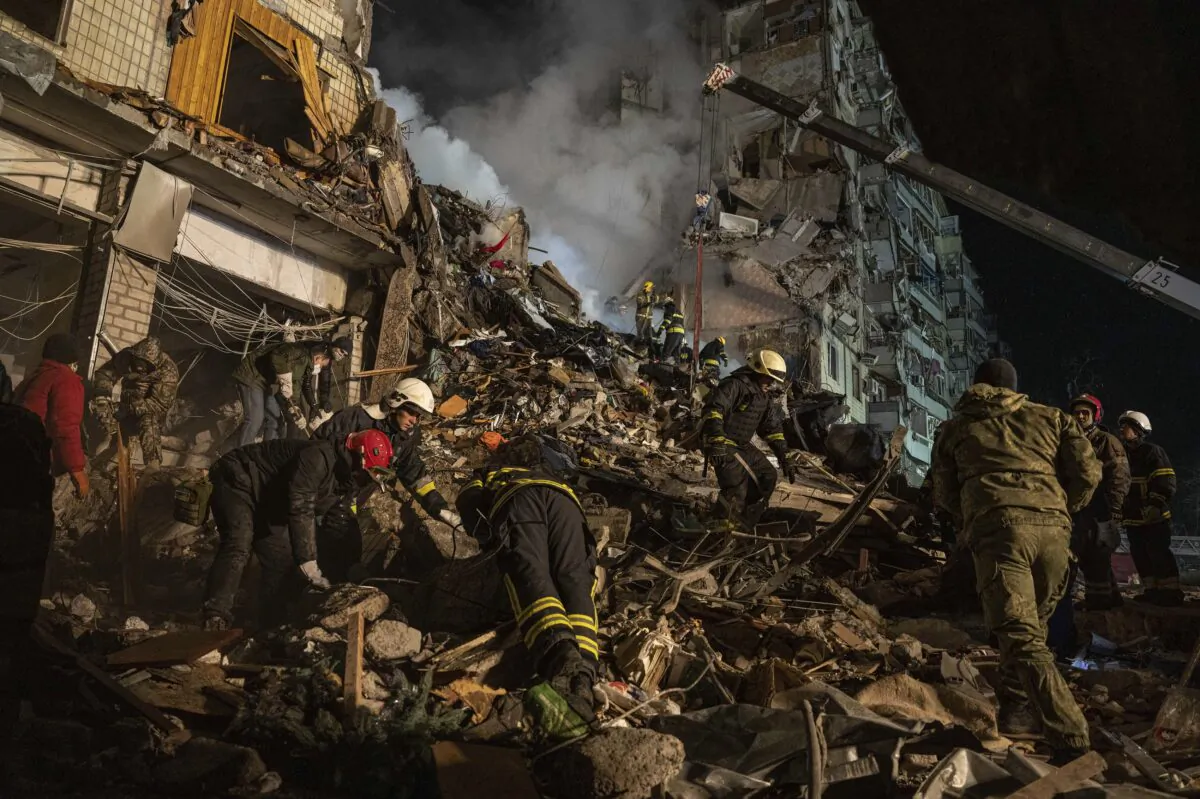 Emergency workers clear the rubble after a Russian rocket hit a multistory building leaving many people under debris in the southeastern city of Dnipro, Ukraine, on Jan. 14, 2023. (Evgeniy Maloletka/AP Photo)
