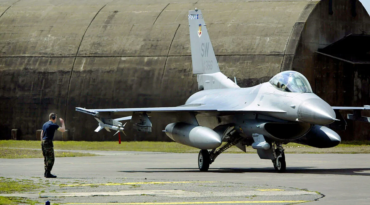 A ground controller salutes an F-16 fighter jet at Incirlik Air Force Base in Turkey on March 7, 2003. (Chris Hondros/Getty Images)