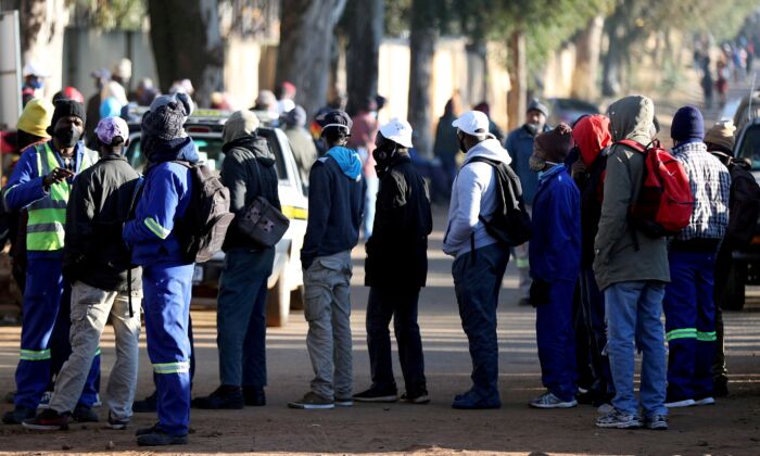 Osoby poszukujące pracy stoją przed placem budowy w Eikenhof, na południe od Johannesburga, RPA, 23 czerwca 2020 r. (Siphiwe Sibeko / Reuters)