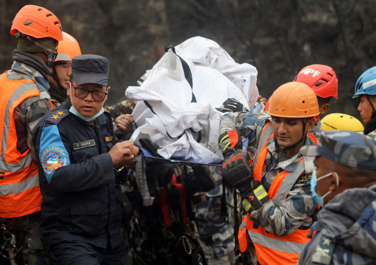 A rescue team recovers the body of a victim from the site of the plane crash of a Yeti Airlines operated aircraft on Jan. 15, 2023, in Pokhara, Nepal, on Jan. 16, 2023. (Bijay Neupane/Reuters)