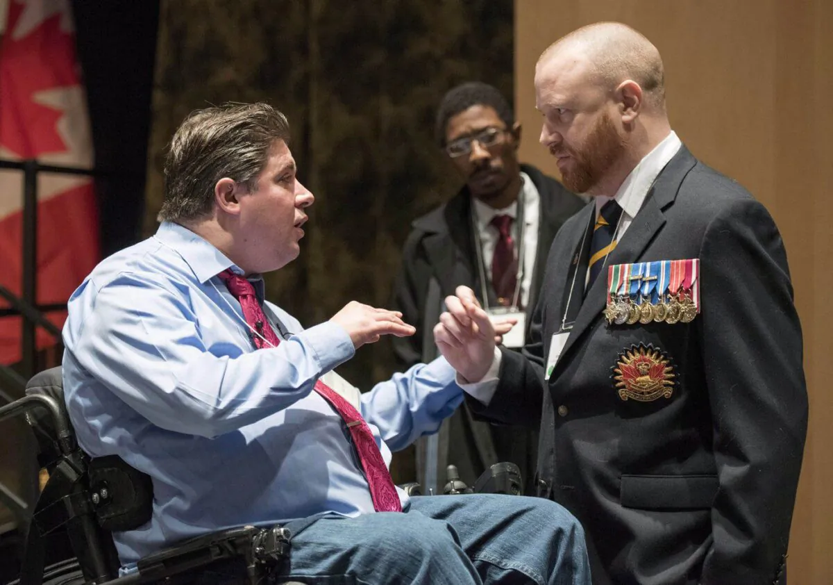 Minister of Veterans Affairs Kent Hehr speaks with veteran Brian McKenna, representing the 39 Brigade Group Wellbeing Network, at a stakeholder summit at the Canadian War Museum in Ottawa on Dec. 2, 2015. (The Canadian Press/Justin Tang)