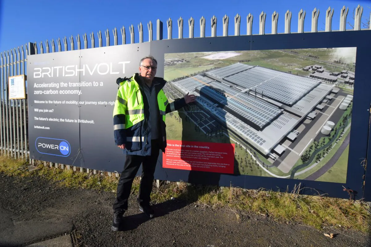 Peter Rolton, executive chairman of electric vehicle battery start-up Britishvolt, shows a billboard at the site of the company's large planned battery plant, in the former industrial town of Blyth, England, on Jan. 27, 2022. (Reuters/Nick Carey)