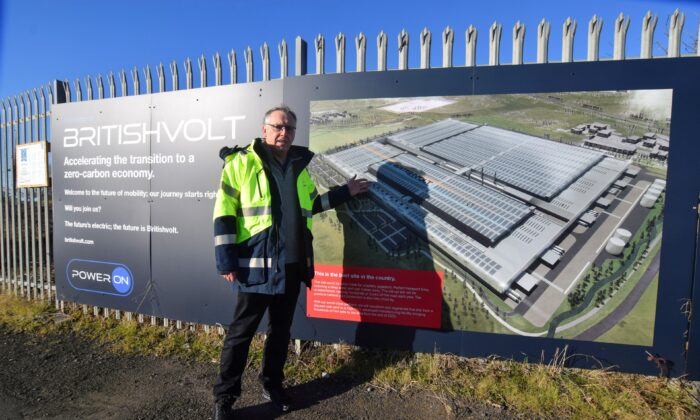 Peter Rolton, executive chairman of electric vehicle battery start-up Britishvolt, shows a billboard at the site of the company's large planned battery plant, in the former industrial town of Blyth, England, on Jan. 27, 2022. (Nick Carey/Reuters)