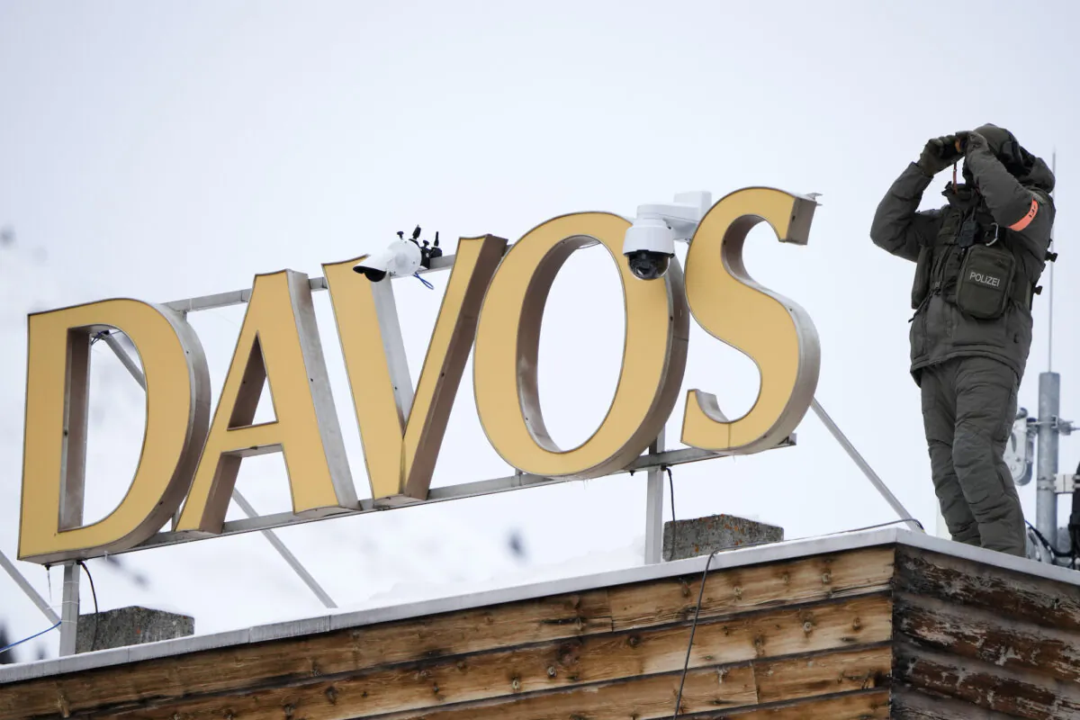 A police officer stands on the roof of a hotel and monitors the area in Davos, Switzerland, on Jan. 16, 2023. (AP Photo/Markus Schreiber)