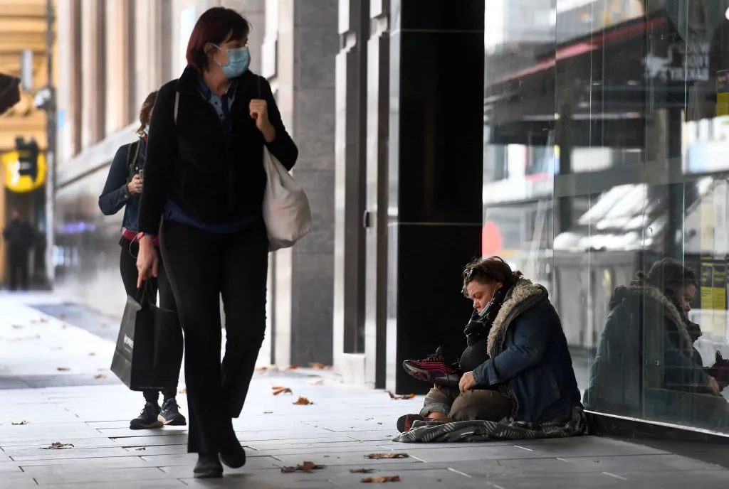 A homeless person sits on the pavement in Melbourne's CBD in Victoria, Australia on June 4, 2021. (William West/AFP via Getty Images)